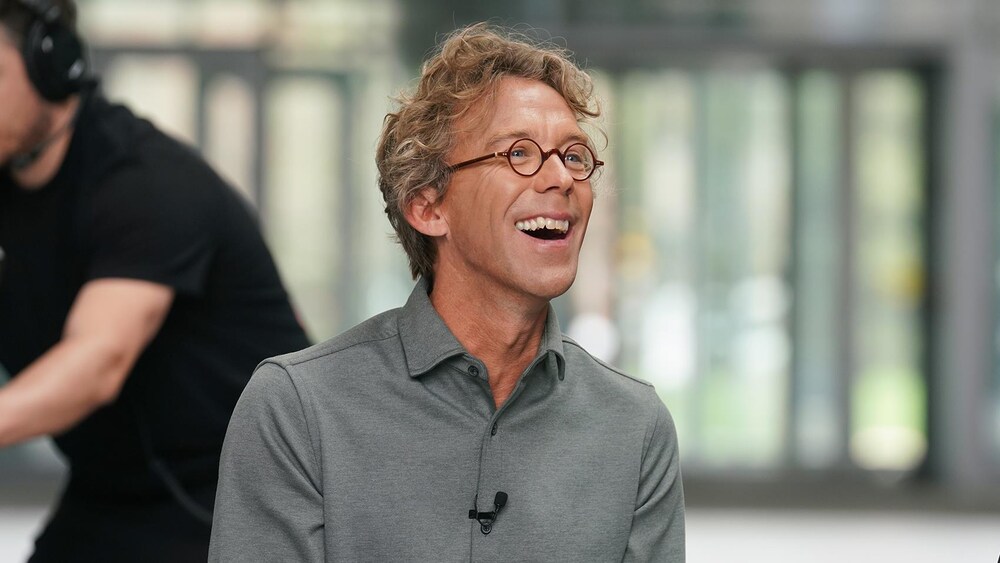 Fred Pellerin regarde devant lui et il rit.
