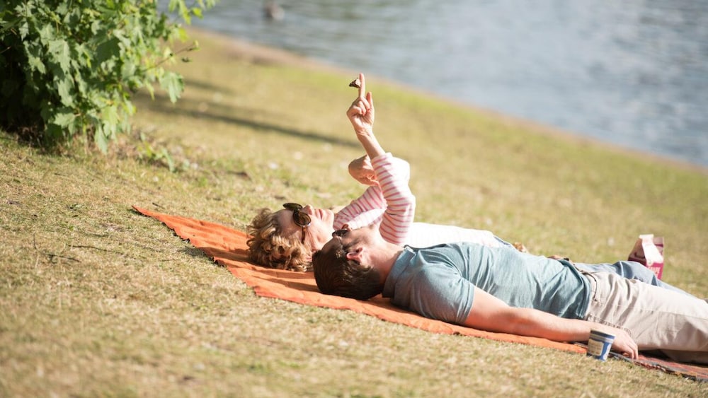 Un homme et une femme allongés côte à côte sur une étendue d'herbe.