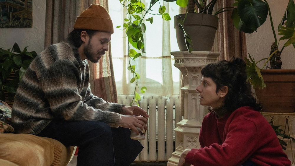 Raphaël (Jean-Carl Boucher) et Sacha (Valérie Tellos) discutent dans le salon.