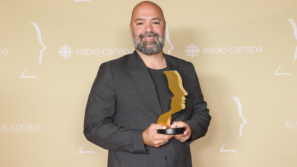 Mani Soleymanlou tient un trophée dans ses mains - au Gala des 41es prix Gémeaux.