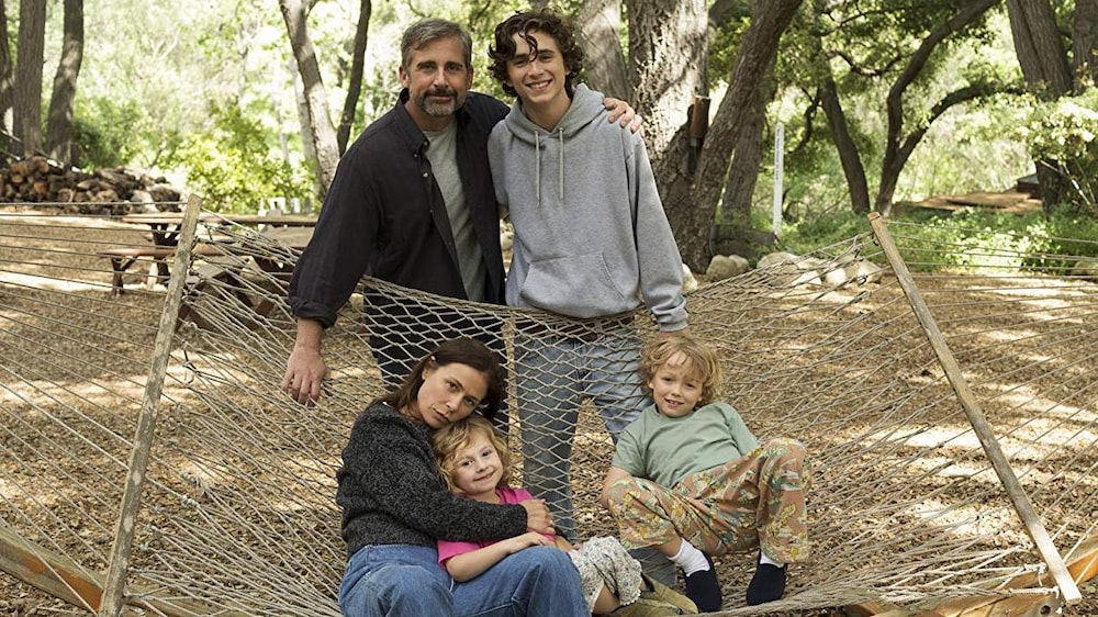 VVS Films Une famille de deux parents et trois enfants regardent la caméra, en plein air, devant un hamac.