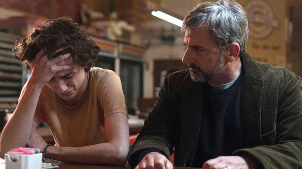 VVS Films Un jeune homme (Timothée Chalamet), la tête dans les mains, assis à côté d'un homme (Steve Carell) qui le regarde.