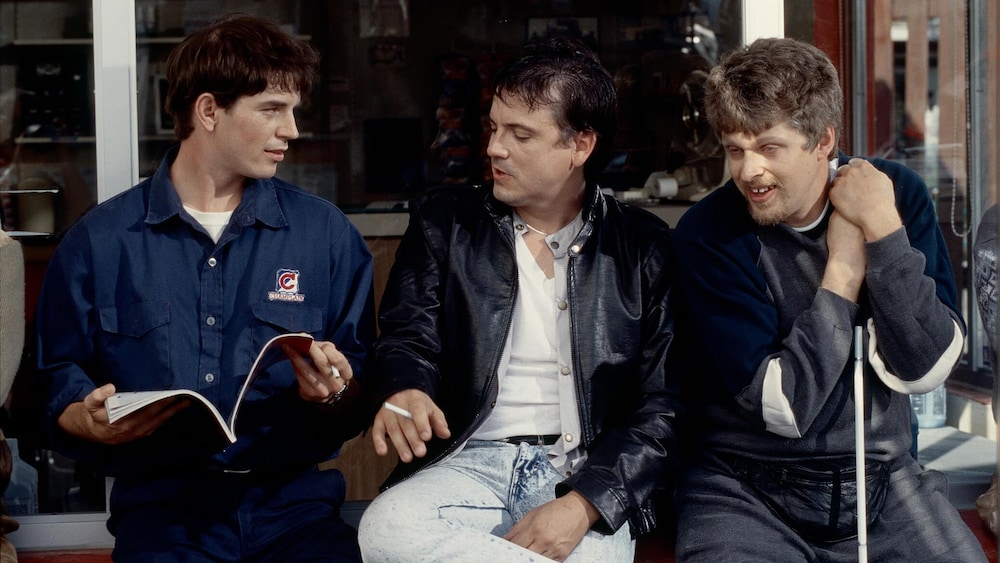 Alliance Vivafilm Trois hommes (Dany Gilmore, Claude Legault et Réal Bossé) assis dans un garage.
