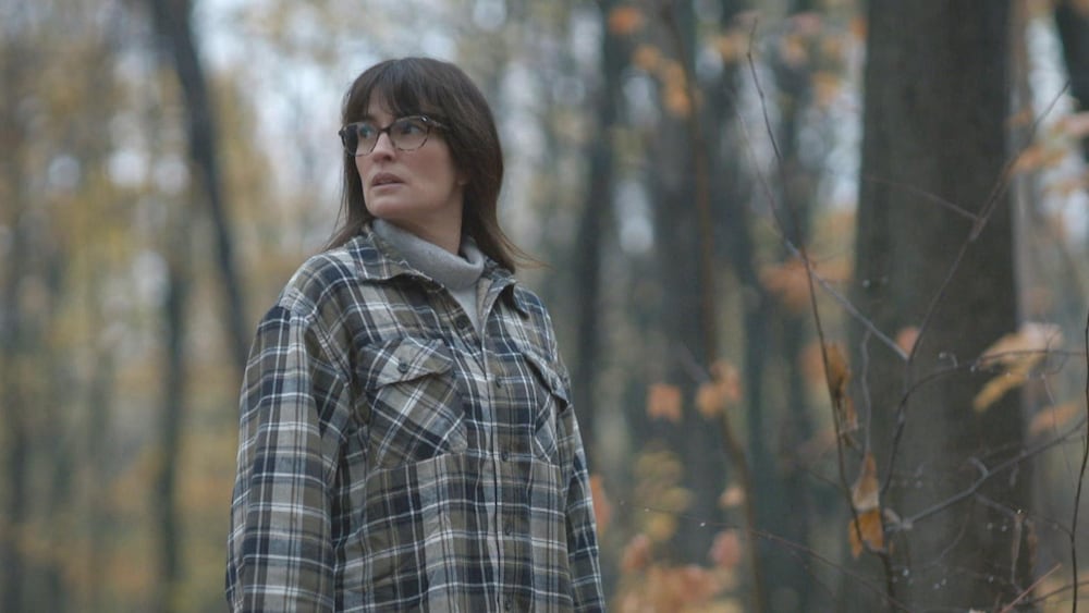 Aetios Productions Geneviève Allard (Madeleine Péloquin) marche dans la forêt.