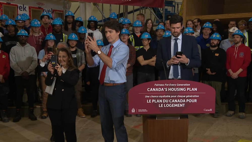 Justin Trudeau se prend en égoportrait pendant une conférence devant des travailleurs de la construction.