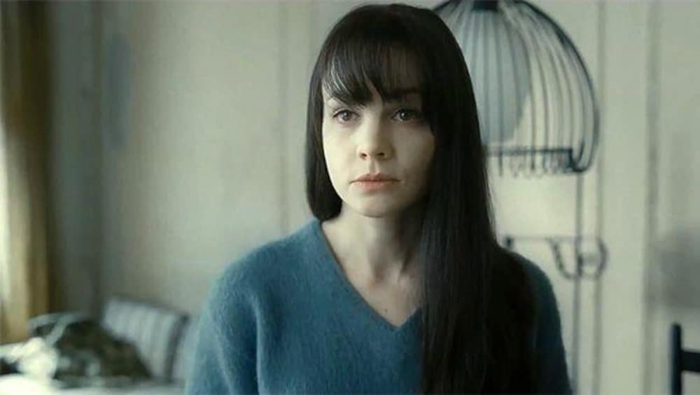 Métropole Films Une jeune femme brune en pull bleu.