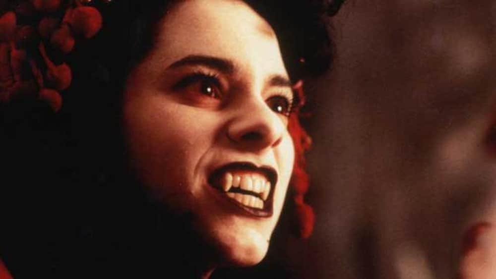 Une jeune fille (Isabelle Cyr) en gros plan, lad   sourire dévoilant deux canines de vampire.