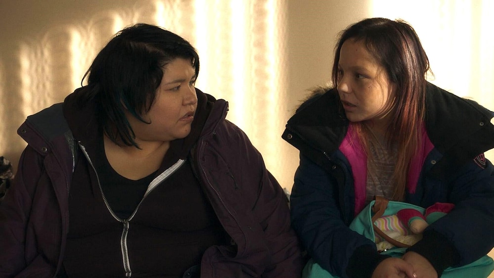 Deux jeunes femmes (Sharon Fontaine-Ishpatao et Yamie Grégoire) assises côte à côte, se regardent.