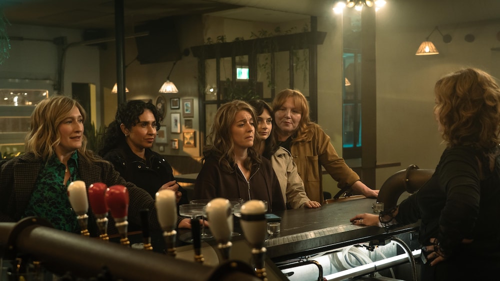 Les cinq femmes sont debout dans un bar.