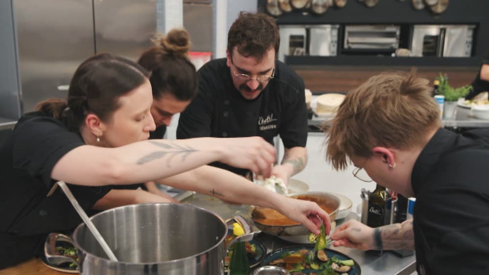 Charlotte, Agathe et Mayara qui aident Sébastien en cuisine.