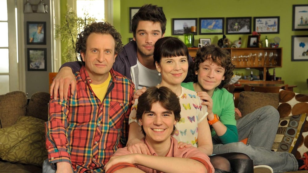 Les personnages sourient à la caméra.