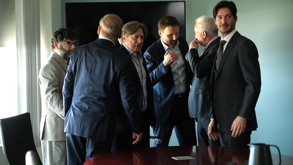 Un groupe d'hommes debout dans une salle de réunion.