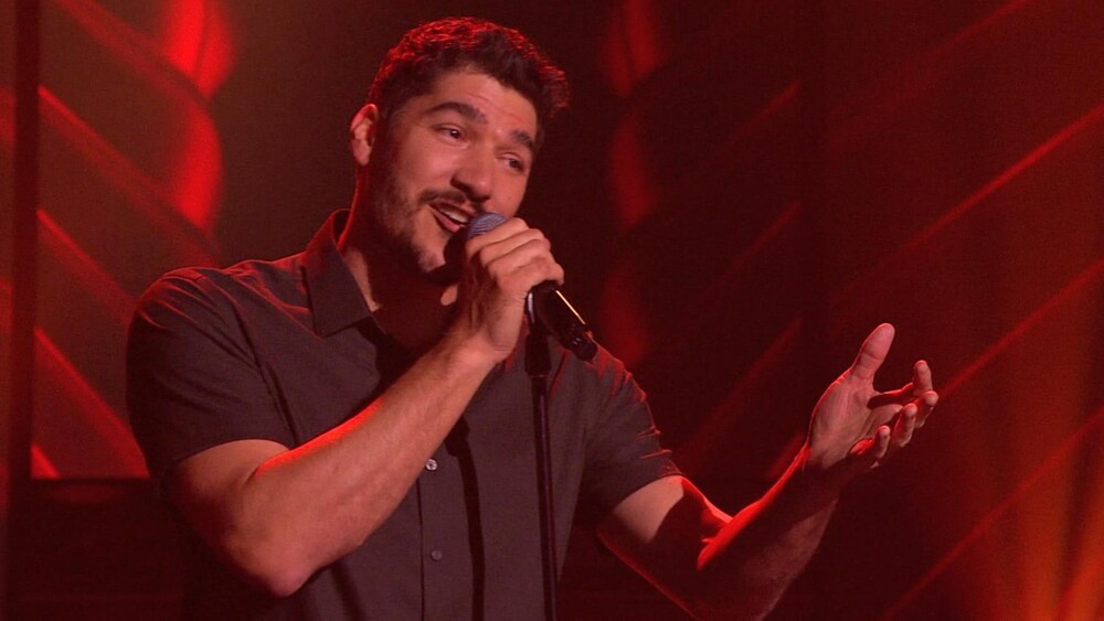 Jason Roy Léveillée chante en tenant un micro.