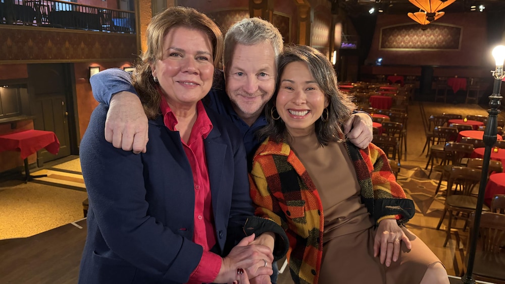 Marina Orsini, Andr&eacute; Robitaille et Kim Th&uacute;y dans une salle de spectacle. Le groupe est coll&eacute; ensemble pour se faire prendre en photo.