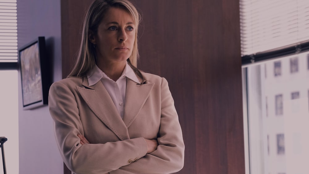 Entract Films Une femme (Christine Beaulieu) se tient les bras croisés dans un bureau.