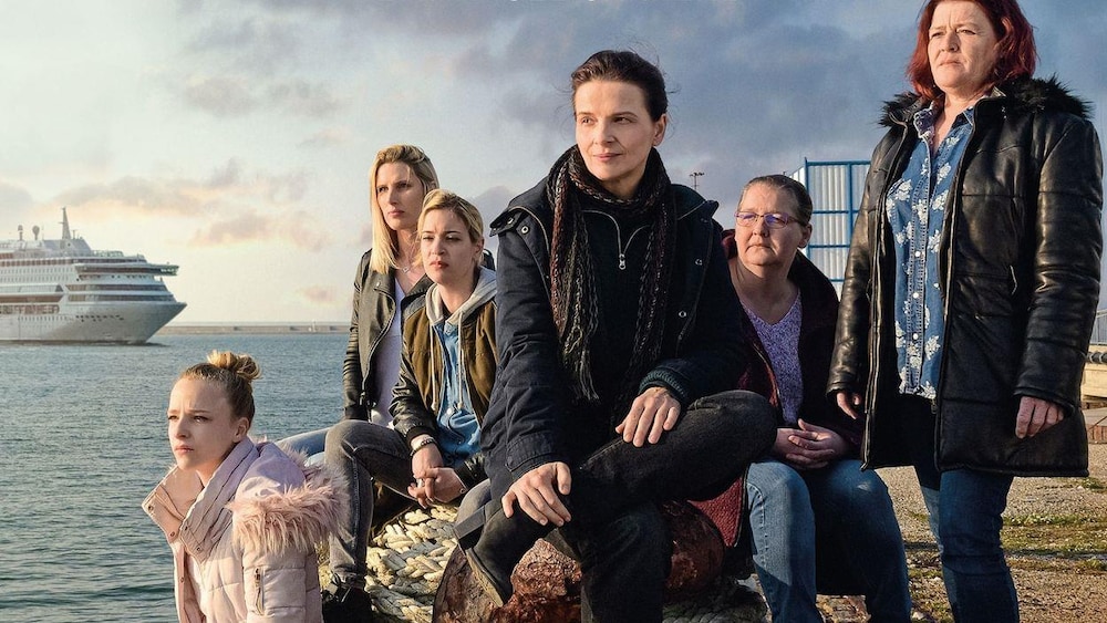 Un groupe de femmes (parmi lesquelles Juliette Binoche) assises sur une grève, devant l'océan.