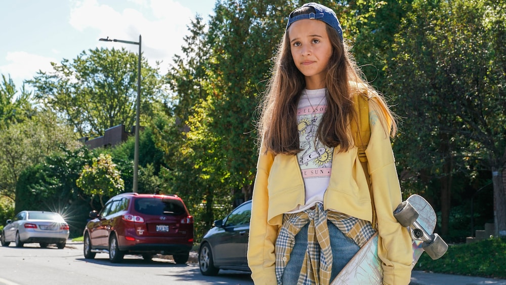 pierre crepo Une jeune fille, dans une rue, un skate à la main.