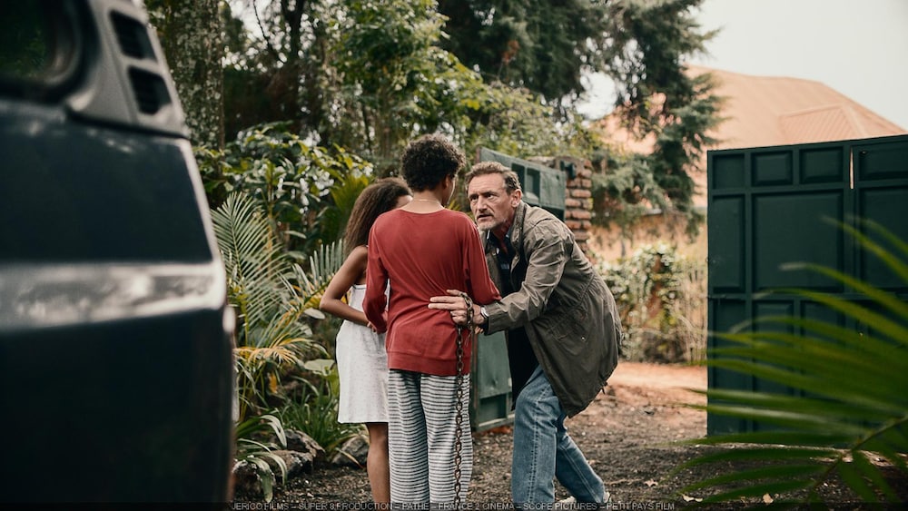 AZ Films Entourés de palmiers, un homme penché avertit deux enfants.