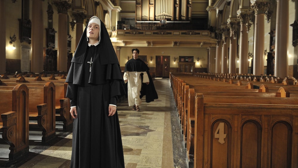 Marlène Gélineau Payette Une soeur en tenue, au milieu d'une église. Un prêtre arrive derrière elle.