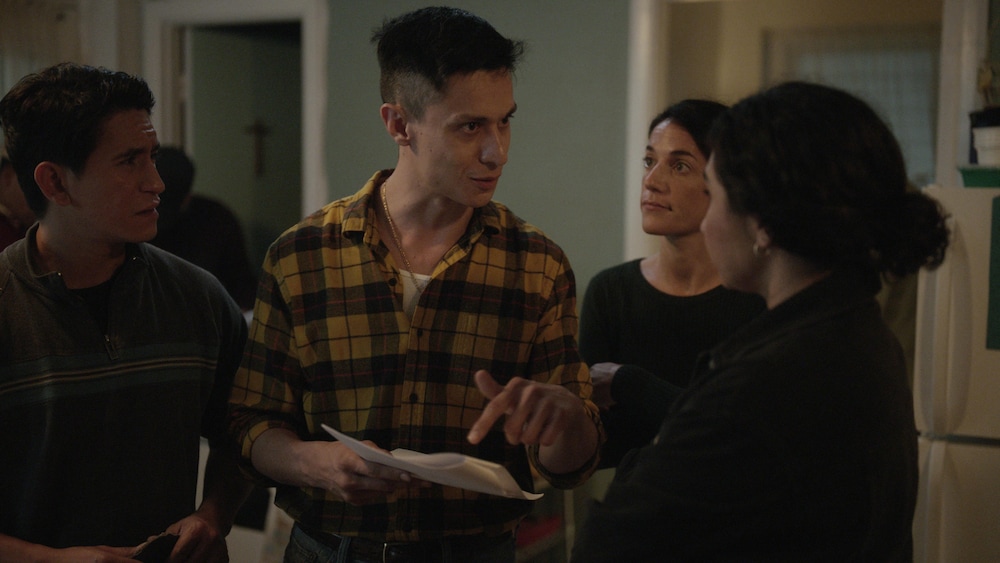 FunFilms Distribution Dans une cuisine, un homme pointe un papier qu'il tient dans ses mains en regardant une femme.