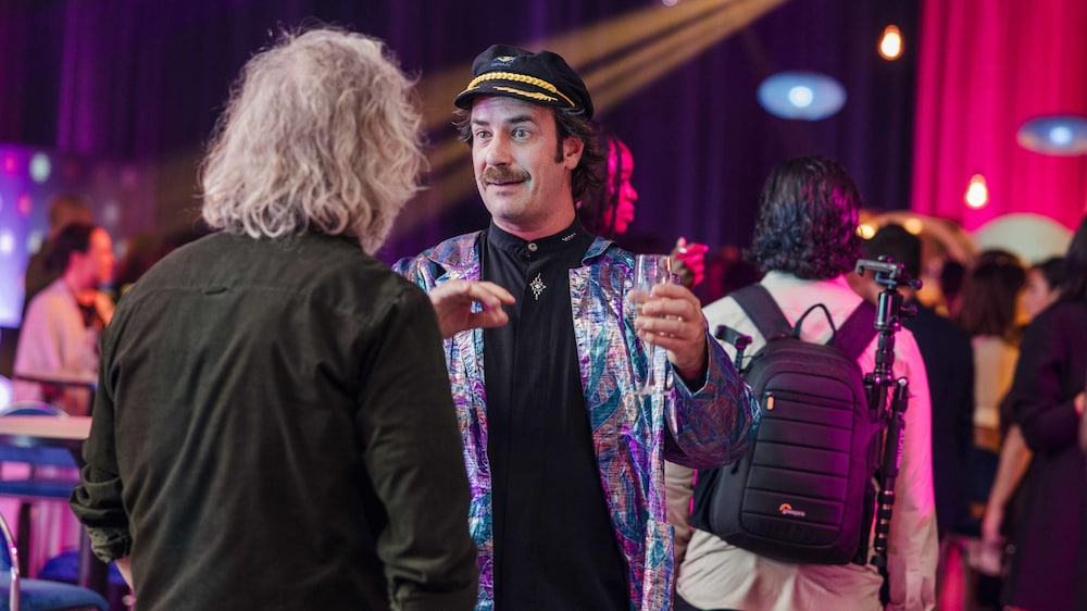 Radio-Canada / Katya Konioukhova Robin Joël Cool et François Bellefeuille discutent un verre à la main à la soirée de lancement dans une ambiance festive.