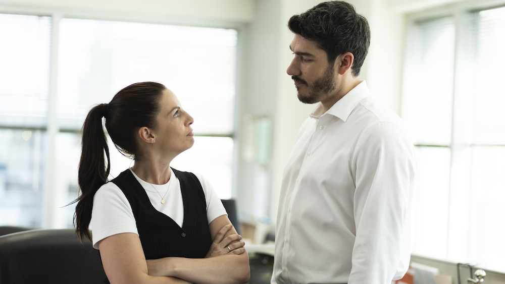Une femme et un homme se regardent dans les yeux. Ils sont dans un bureau.