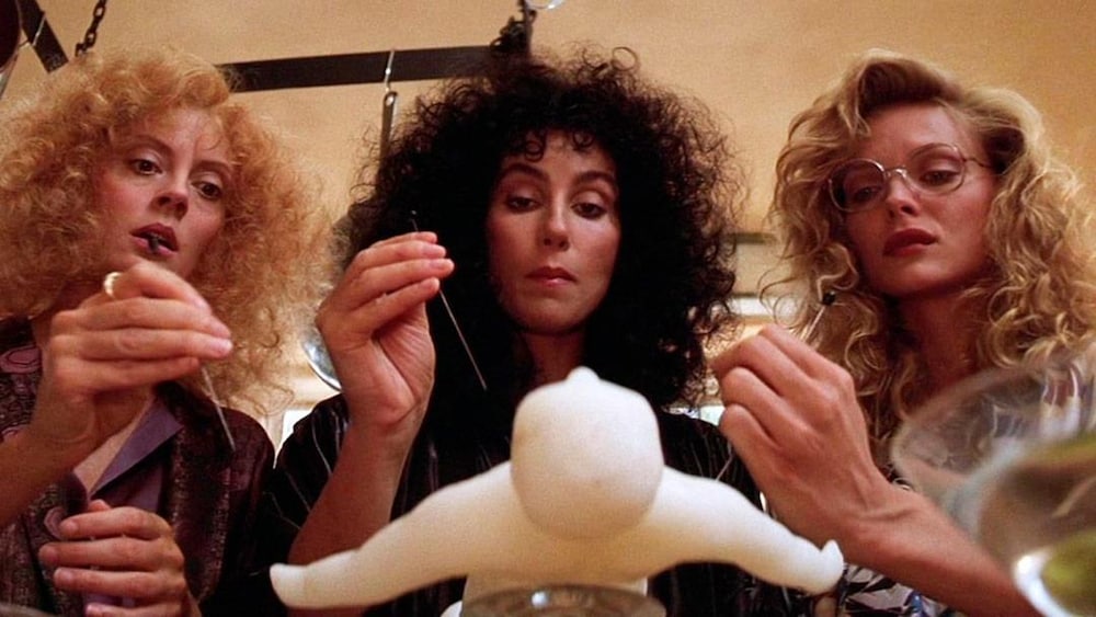 Trois femmes piquent une poupée.