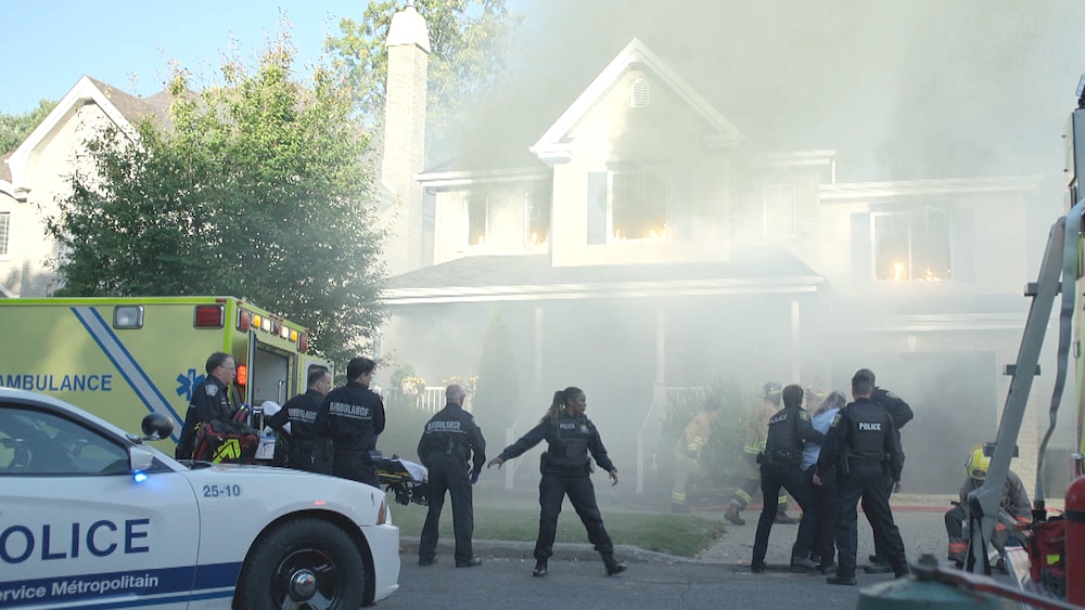 Aetios Productions Les services de secours sont devant la maison d'Isabelle et il y a beaucoup de fumé.