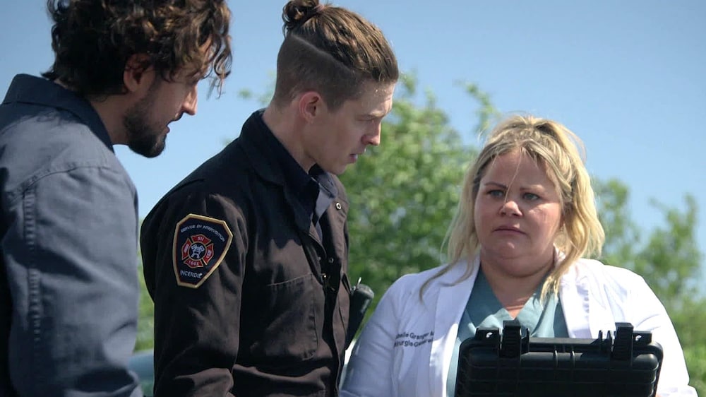 Aetios Isabelle est dans le stationnement de l'hôpital avec deux policiers.