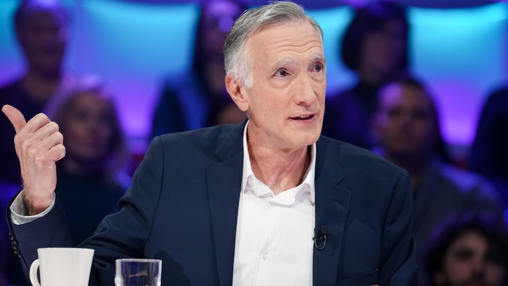 Daniel Renaud est assis dans le studio.