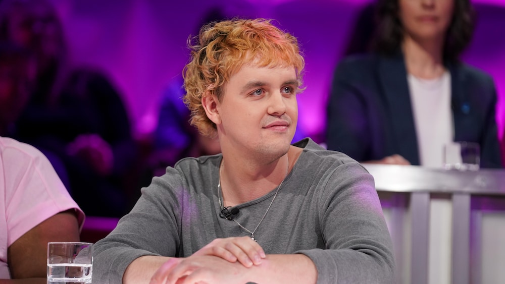 Les Louanges est assis dans le studio.