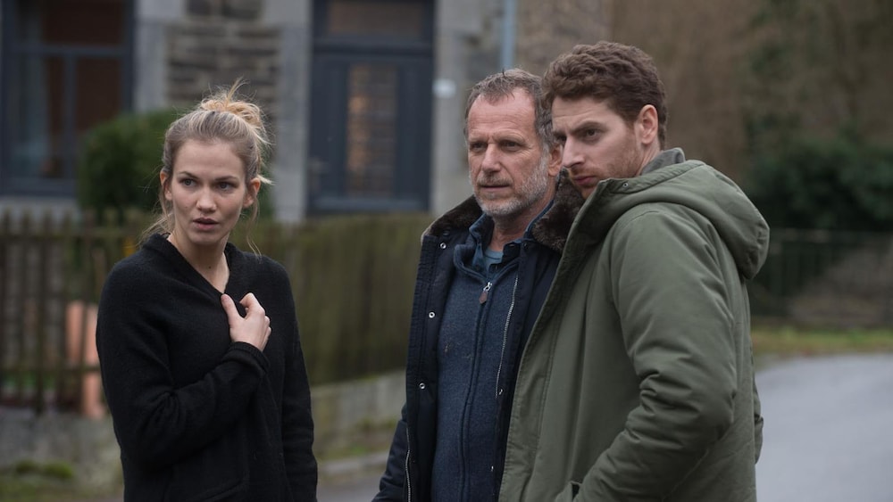 Deux hommes et une femme, dans une rue.