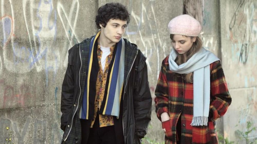 Un jeune homme et une jeune femme marchent dans la rue.