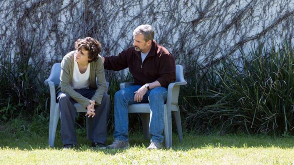 VVS Films Un homme (Steve Carrell) et un jeune homme (Timothée Chalamet) assis côte à côte dans un jardin.