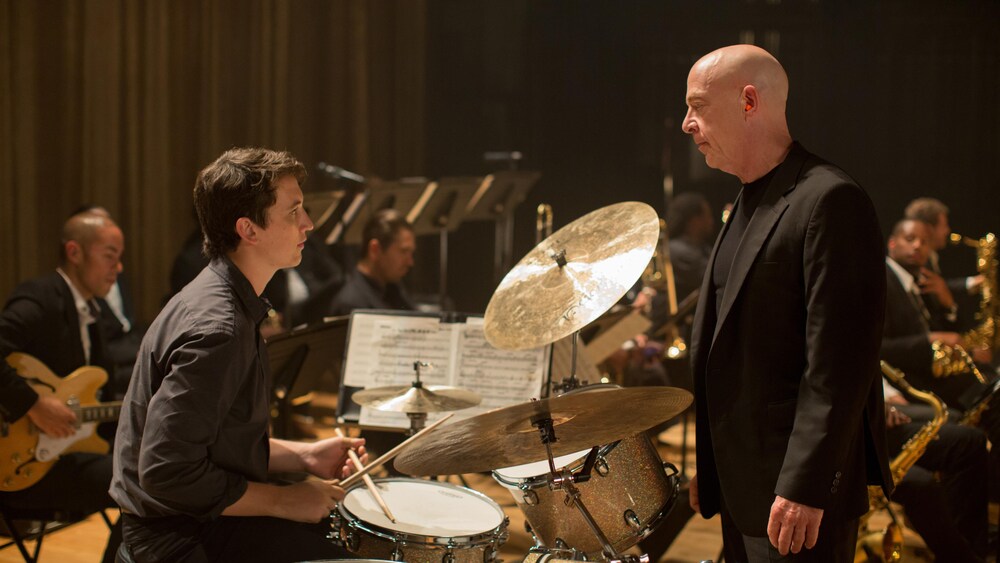 Daniel McFadden Un jeune batteur (Miles Teller) assis derrière son instrument, face à un homme en complet noir (J.K. Simmons)