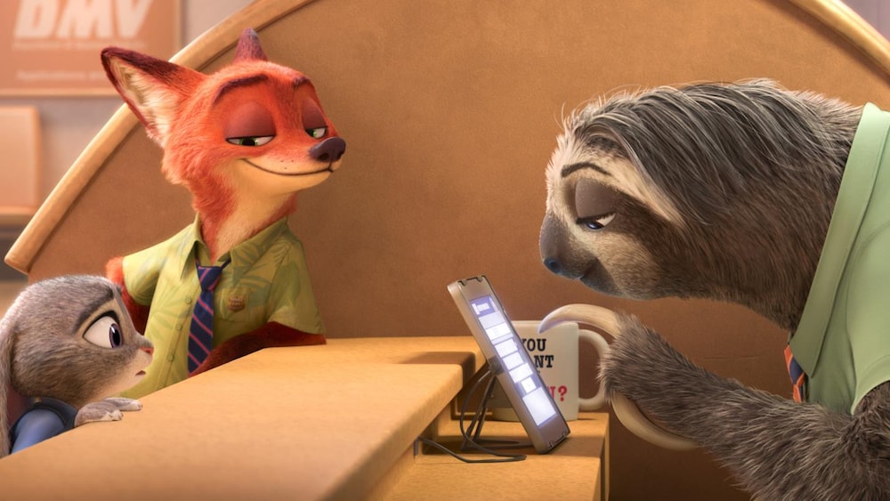 Disney Une lapine et un renard de l'autre côté d'un comptoir où se tient un paresseux qui regarde un écran.