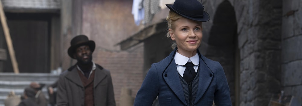 Eliza Scarlet (Kate Phillips) marche dans une rue de Londres du 19e siècle.