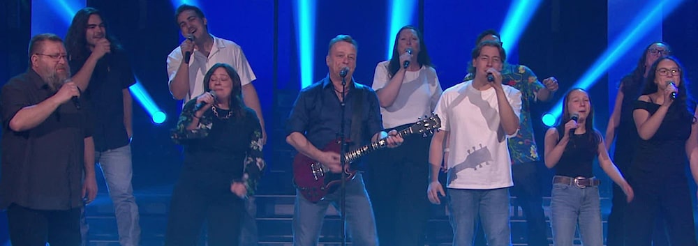 Une dizaine de membre de la famille de Mégan Brouillard chantent avec Daniel Boucher.