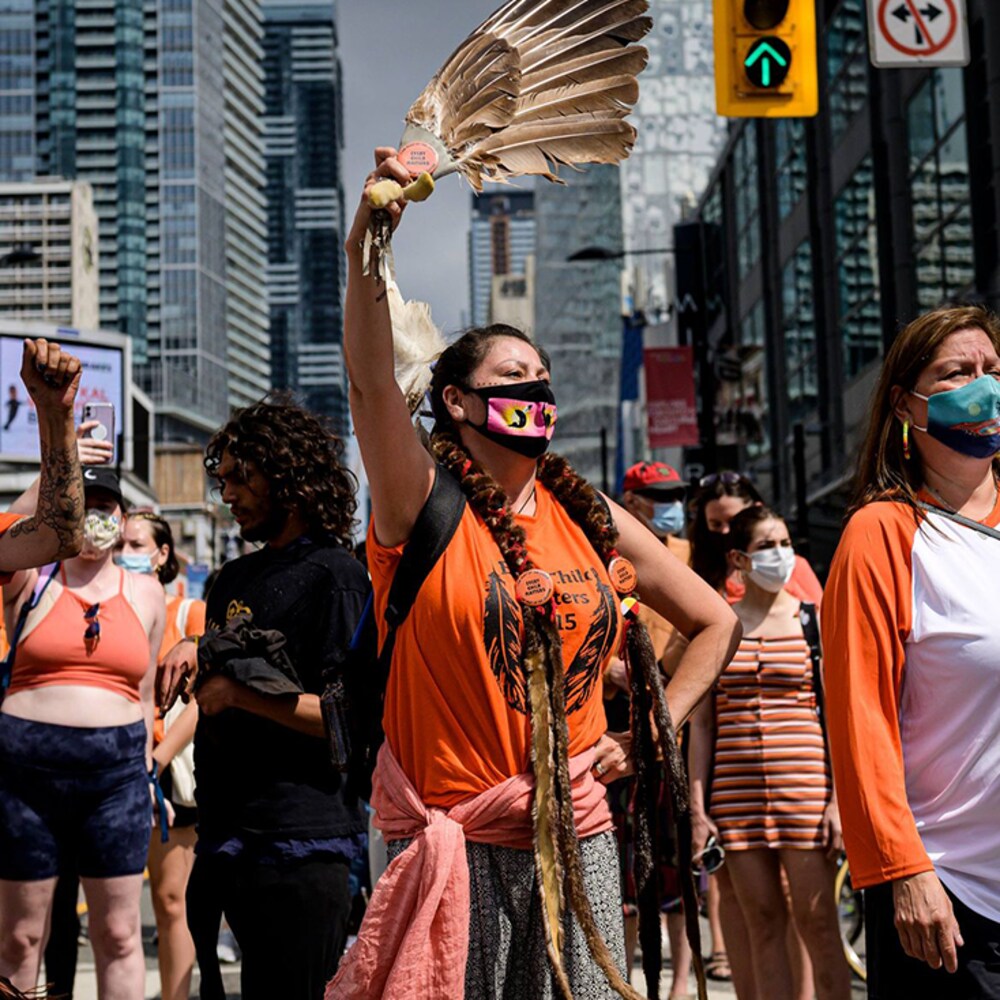 À Toronto, des gens sont réunies lors d'une marche en hommage des victimes des pensionnats pour autochtones