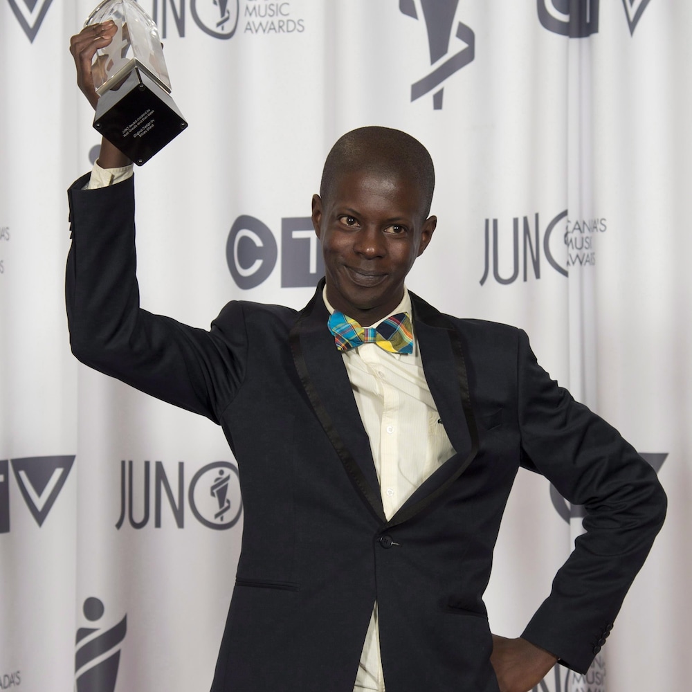 Karim Ouellet sourit en brandissant le prix Juno qu'il a reçu en 2014 pour l'album francophone de l'année.