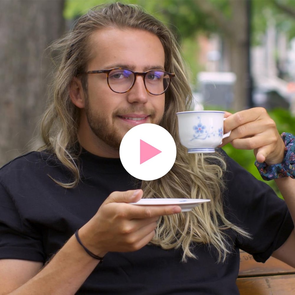 Mathieu Dufour lève une tasse de thé en arborant un sourire malaisé.