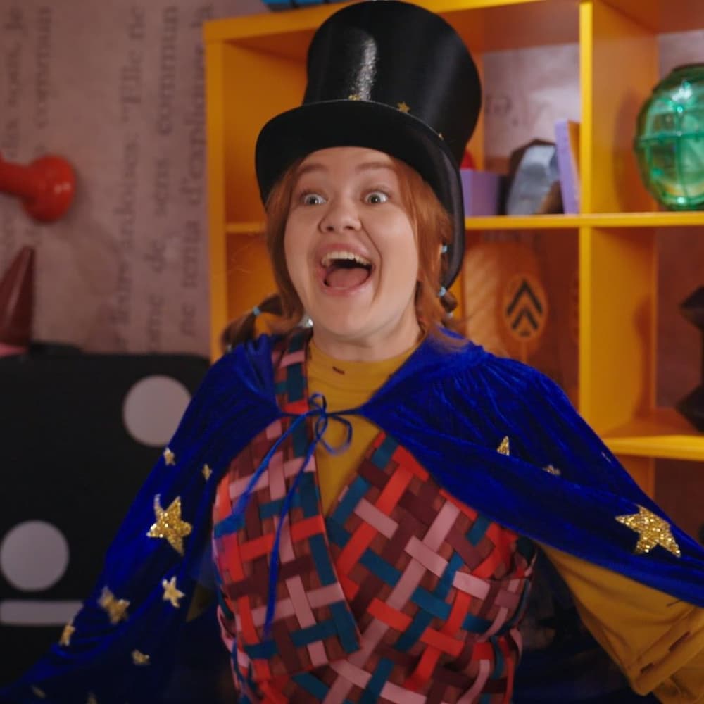 Elle rit en portant un chapeau haut-de-forme. 