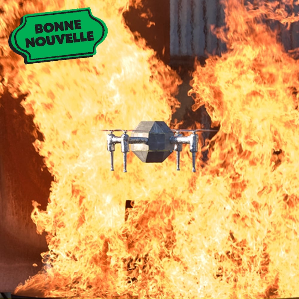 Un drone en métal qui vole par dessus d'un feu, avec le texte "Bonne nouvelle"