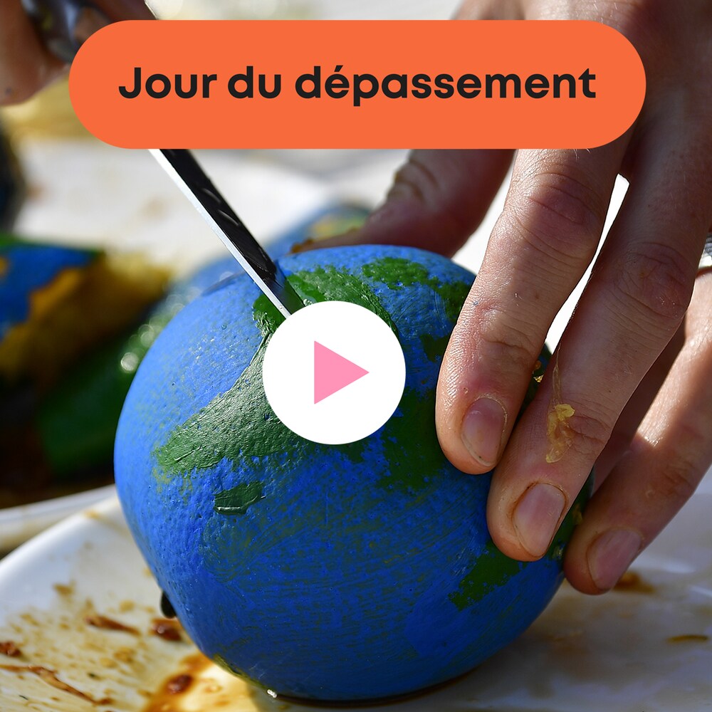 Deux mains qui coupent un orange peint comme la planète Terre, à côté d'un bouton « Jouer » et le texte « Jour du dépassement ».