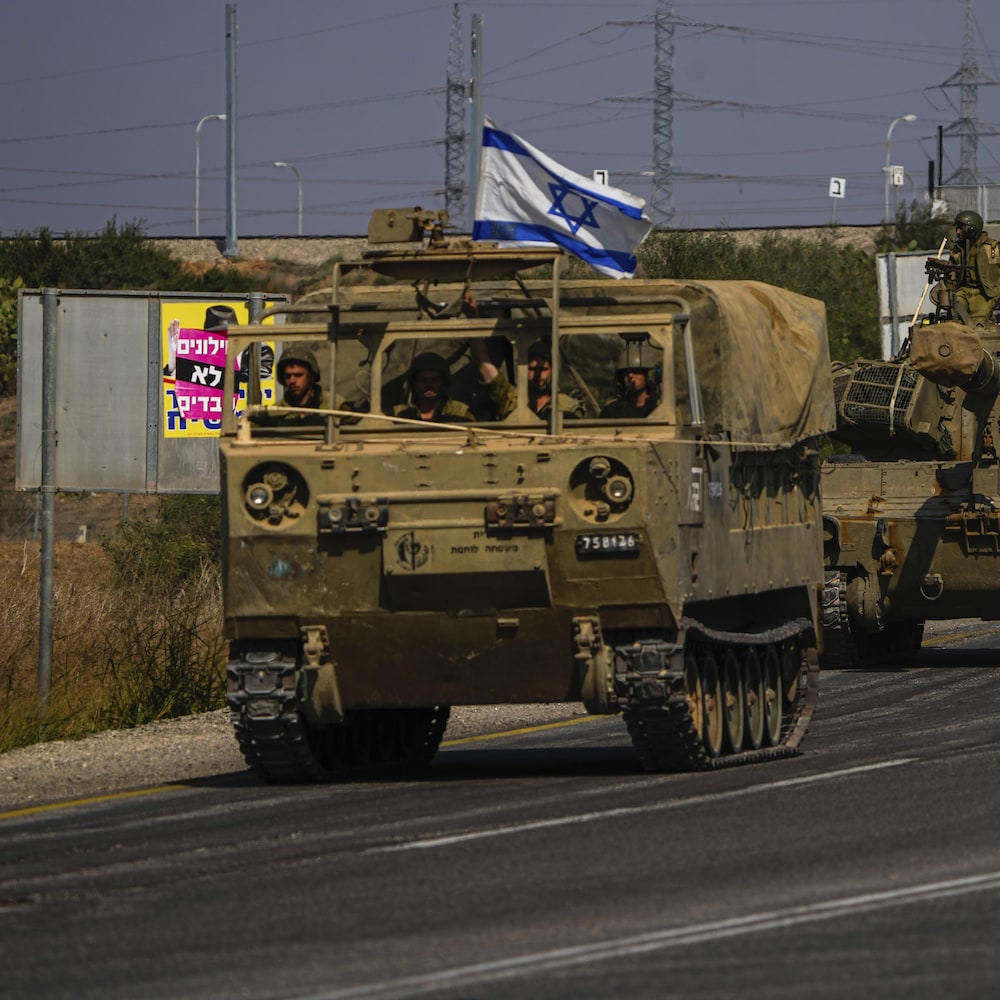 Des tanks de l'armée israélienne se déplacent vers la frontière de Gaza. Un d'eux porte le drapeau israélien. 