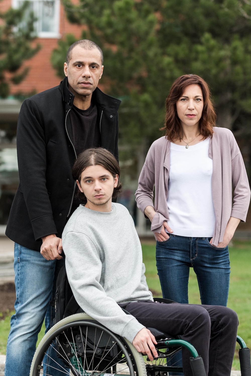 Robin est en fauteuil roulant, ses parents sont derrière lui. 