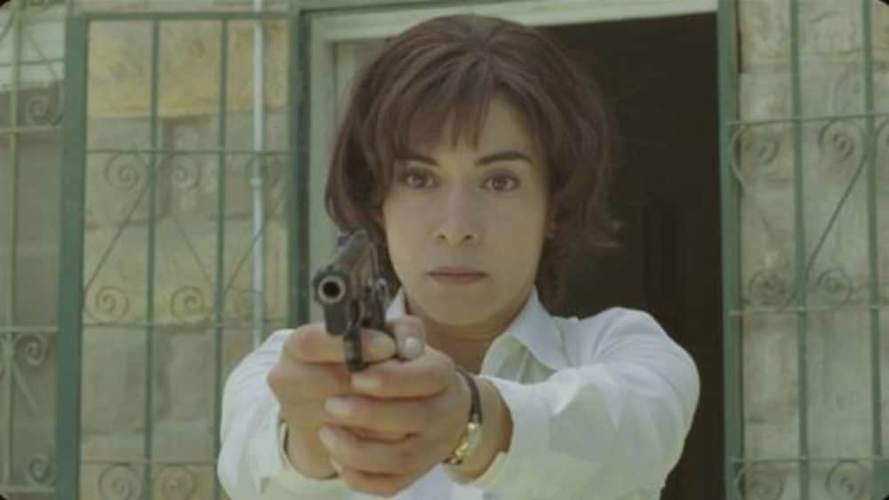 Une femme vise avec un revolver