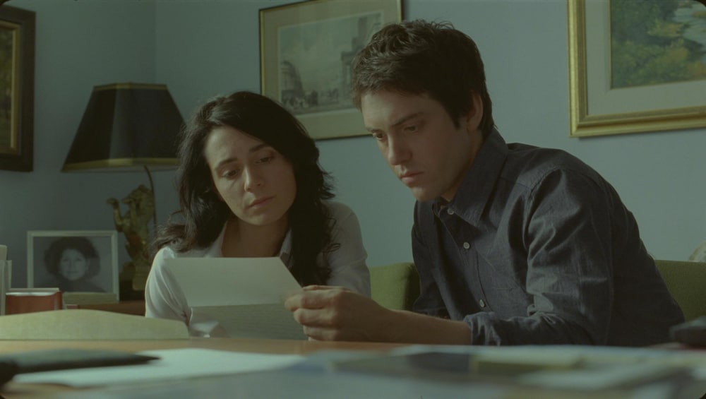 Un jeune homme et une jeune femme lisent une lettre