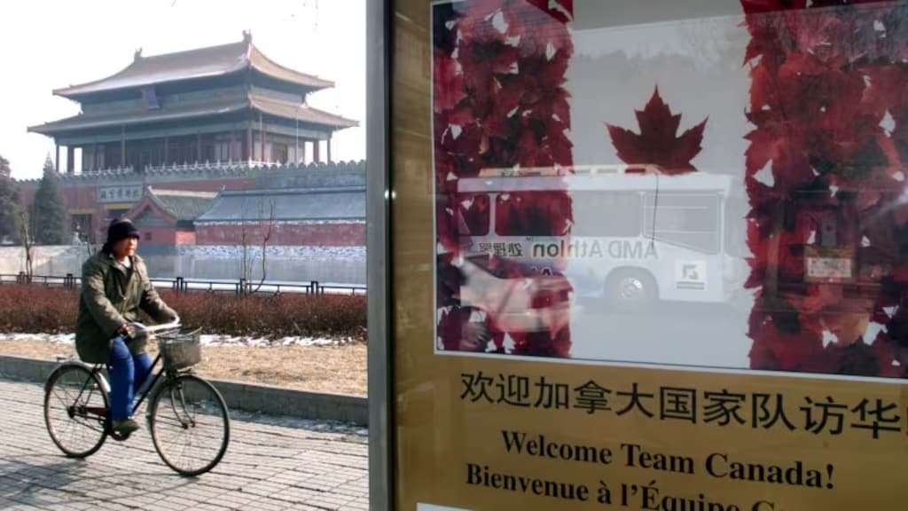 A Chinese man cycles past a billboard in front of Beijing's Forbidden City before a 2001 visit by then-Canadian prime minister Jean Chretien. At the time, concerned U.S. officials were secretly probing Chinese operations in Canada. (Reuters)