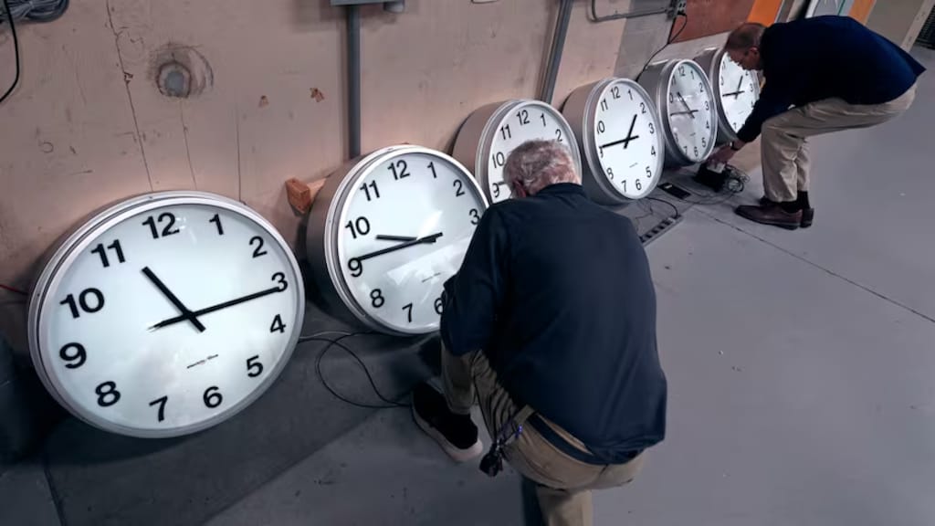 Dos personas frente a relojes.